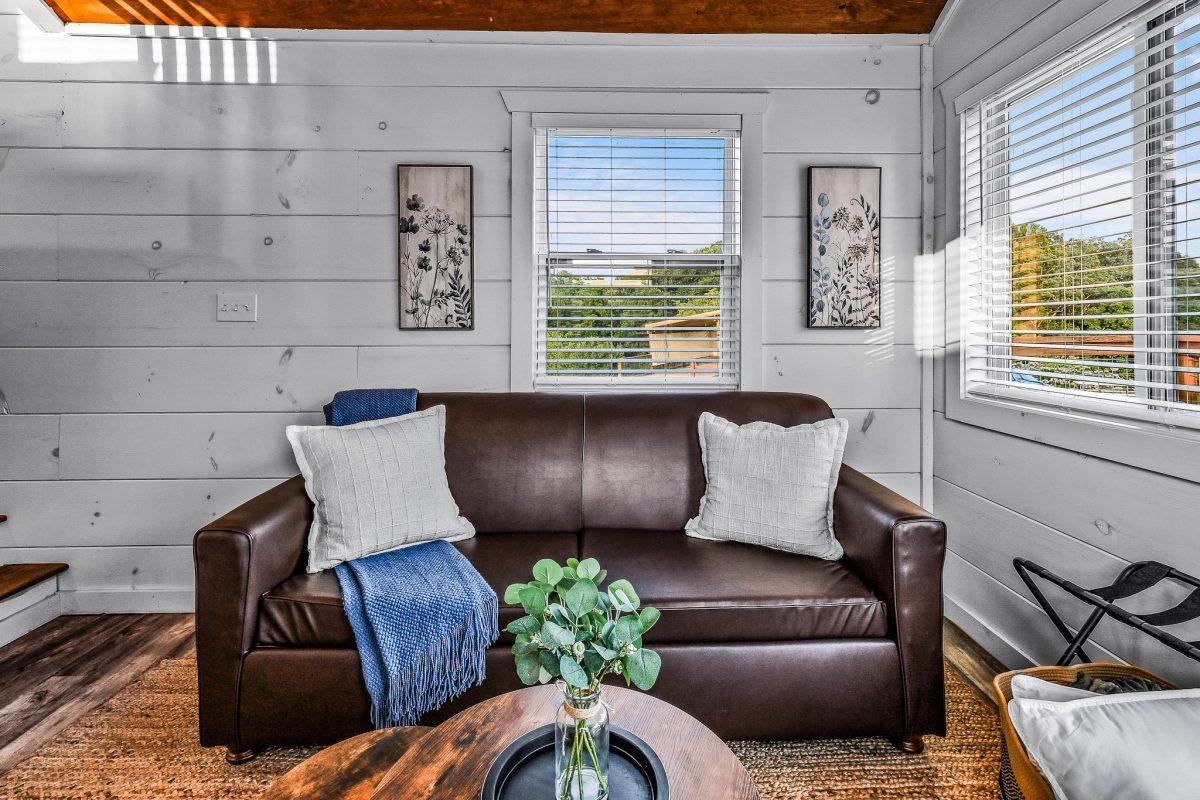 Living room area inside the tiny home with leather couch