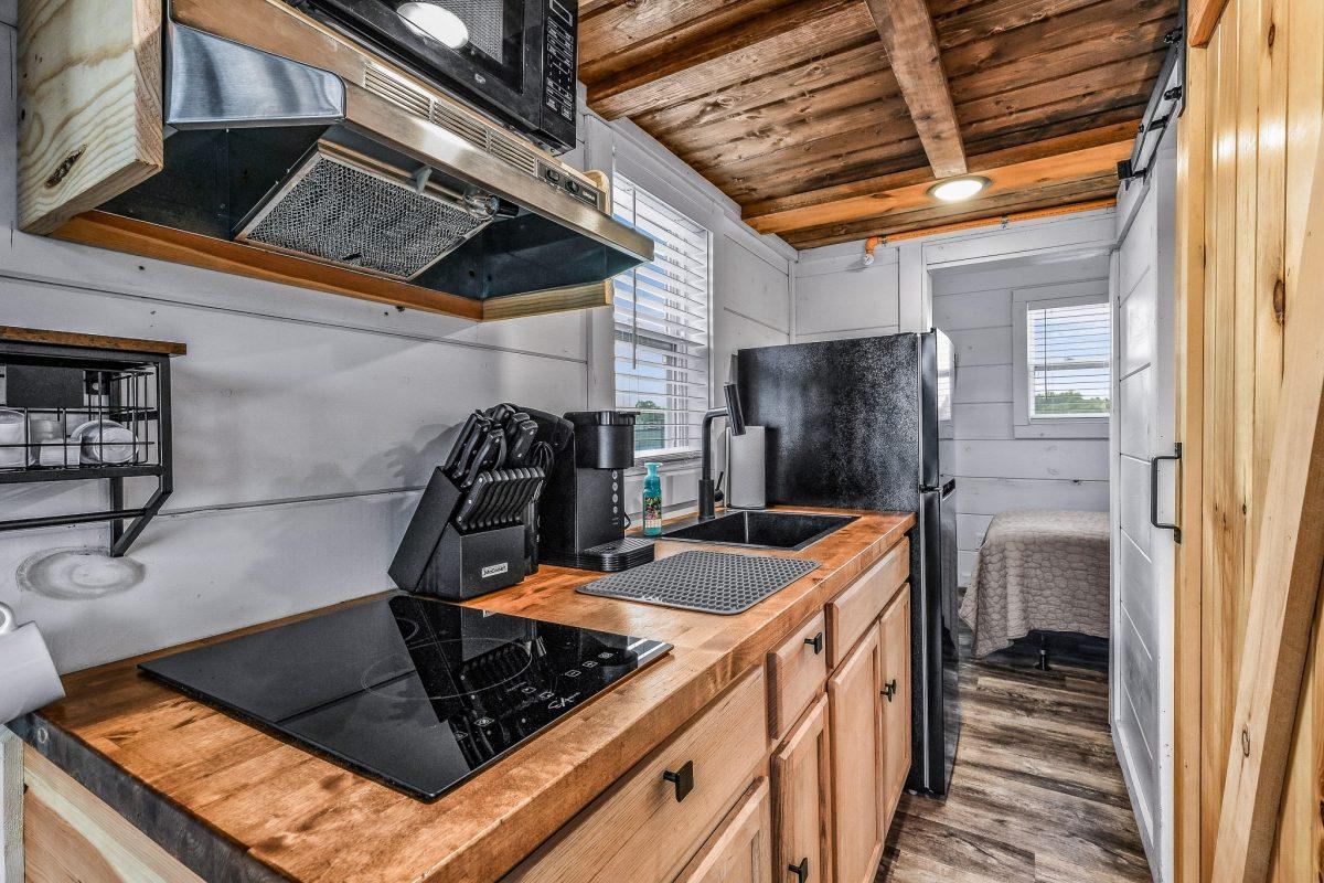 Kitchenette in the tiny home with stovetop, coffee maker, and microwave