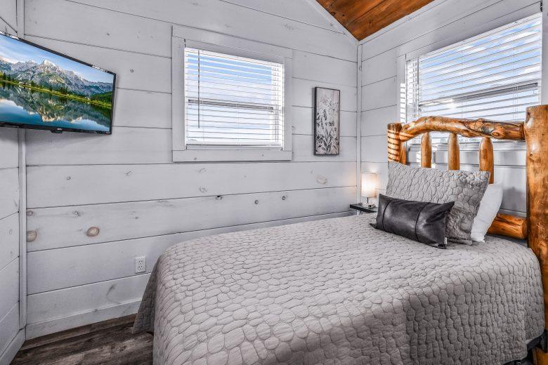Bed with gray bedding inside a tiny home