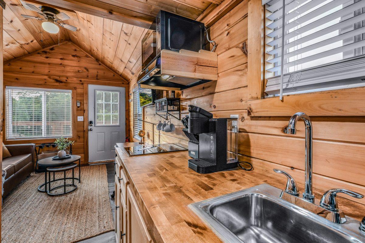View of kitchenette with wooden cabinets, coffee maker, and stovetop