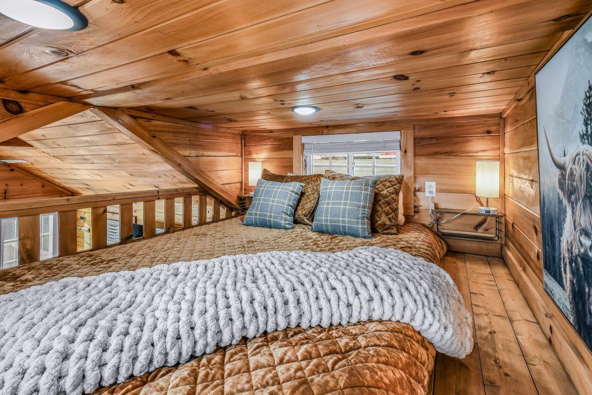 Loft sleeping area with brown bedding and plaid pillows